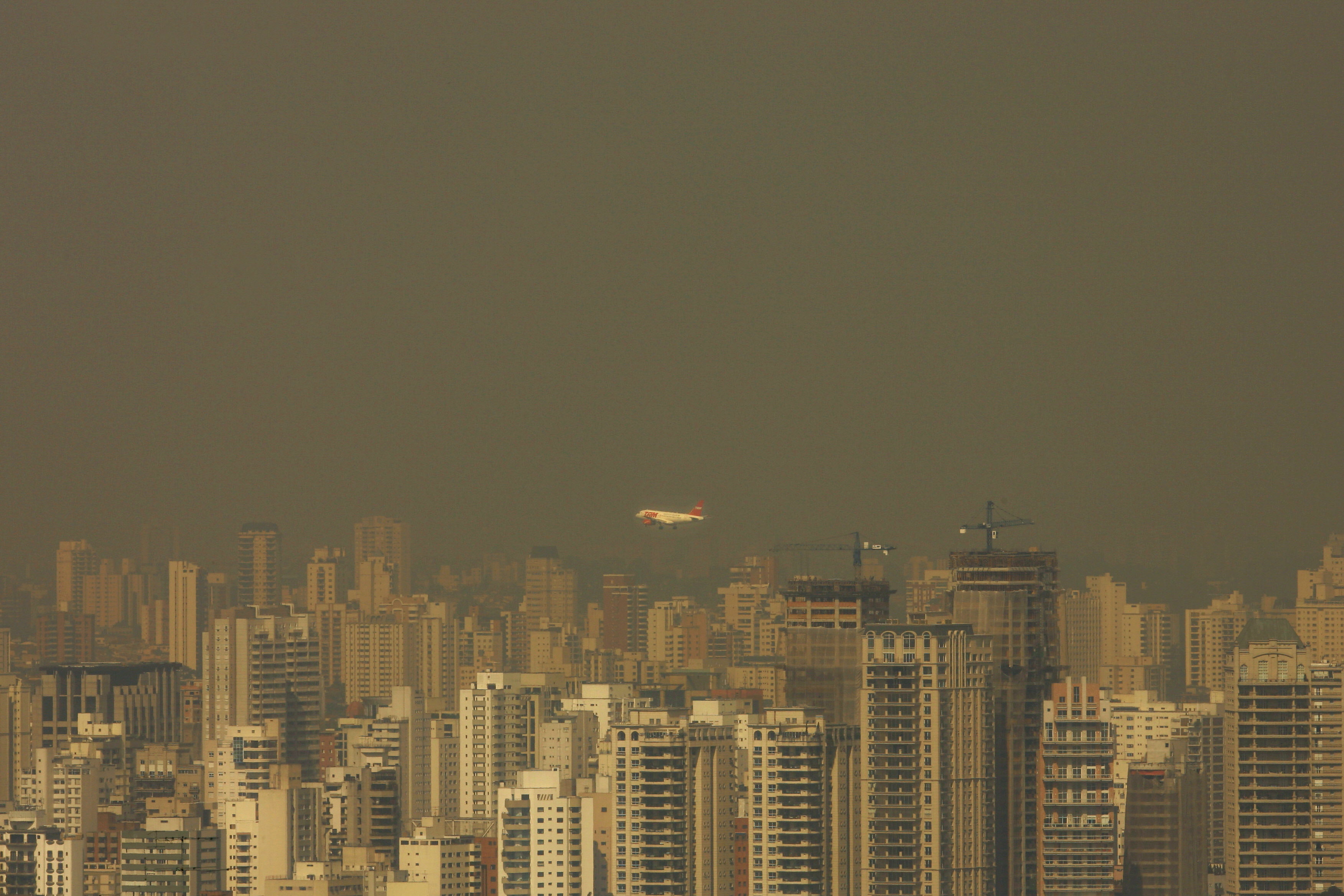 Avião sobrevoa o bairro de Moema, em São Paulo: poluição no Brasil caiu pela metade entre 2005 e 2010. A foto mostra a capital paulista em 2008 | AFP / Arquivo/Mauricio Lima