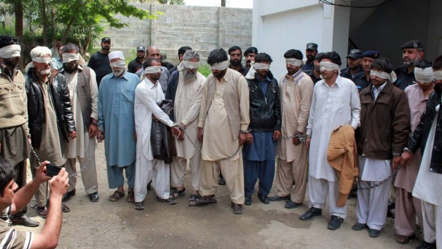 Suspeitos são levados pela polícia paquistanesa | Shakeel Ahmed/AFP