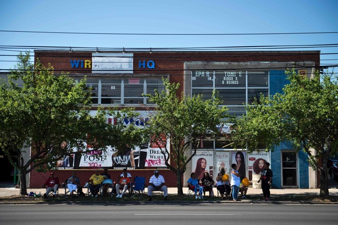 Moradores de Louisville improvisaram assentos para poder acompanhar a procissão que levaria os restos mortais de Muhammad Ali ao cemitério. | Brendam Smialowski AFP