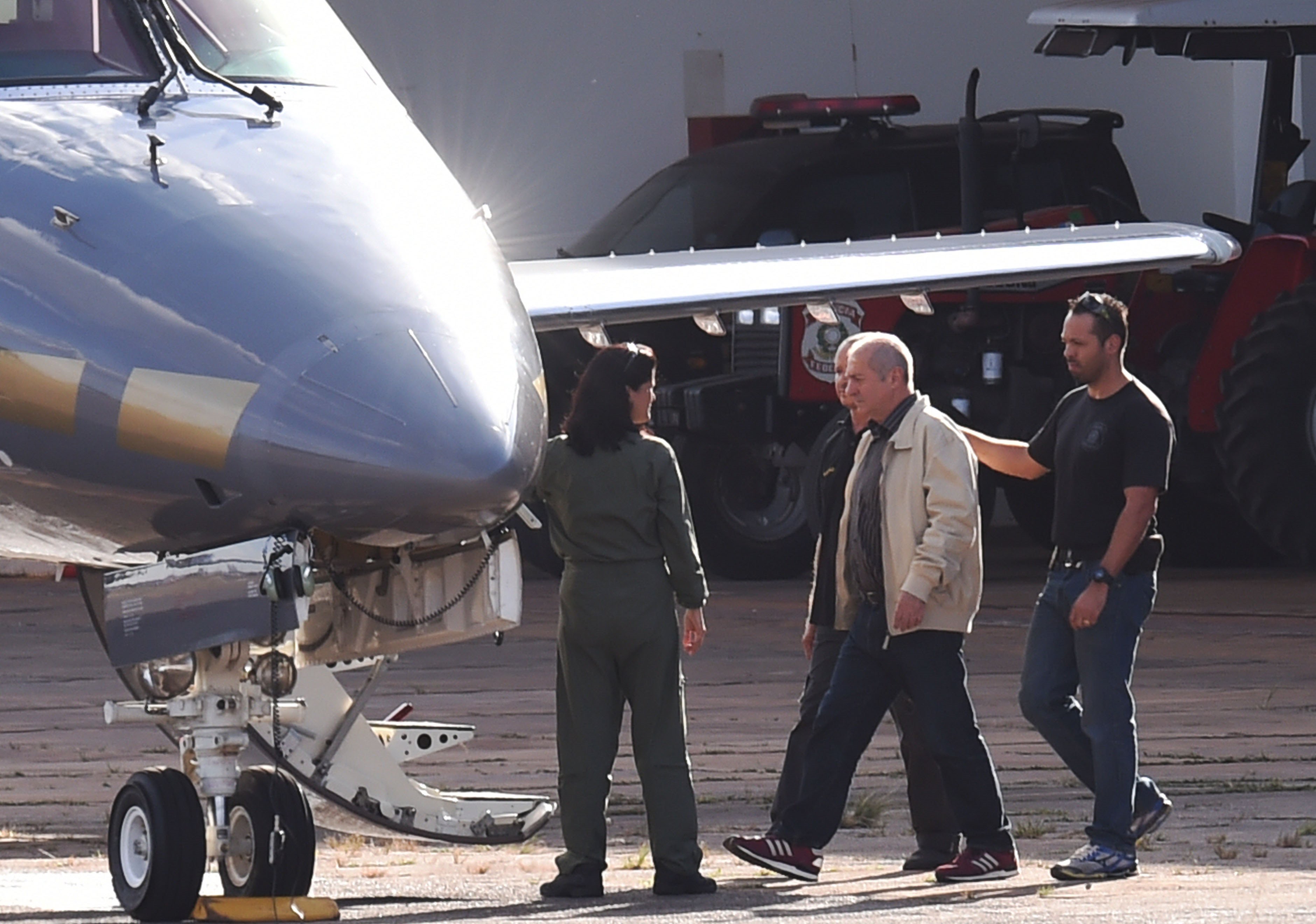 Agentes da Polícia Federal conduzem Paulo Bernardo (de bege) para o avião que o levou preso de Brasília a São Paulo, onde estão concentradas as investigações contra o ex-ministro. | Evaristo Sá/AFP
