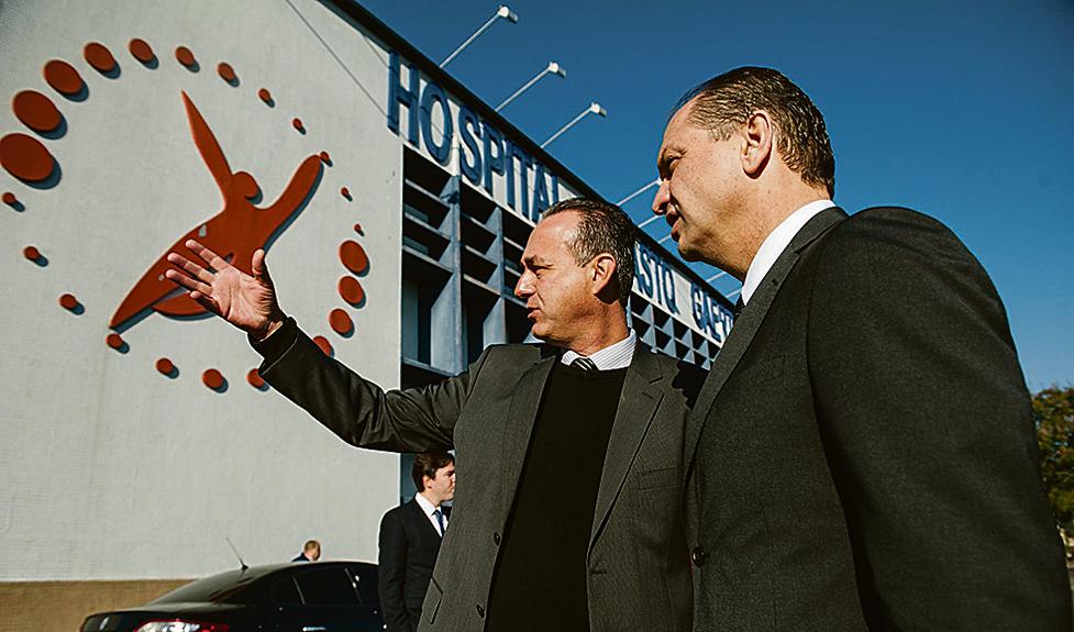 MÃO AMIGA – O superintendente do Hospital Erasto Gaertner, Adriano Lago (à esq.), recepcionou o ministro da Saúde, Ricardo Barros, no último final de semana. Ele conheceu as instalações onde serão executados, nos próximos 24 meses, dois projetos com recursos captados pelo Programa Nacional de Apoio à Atenção Oncológica. | Divulgação