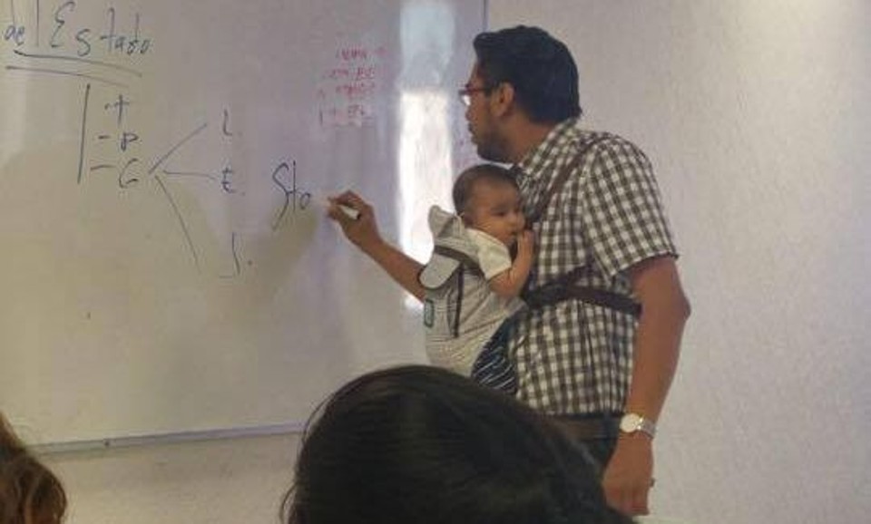 Como o menino queria ficar em pé, quando o professor o colocou no colo, ele ficou tranquilo e a aula seguiu normalmente | Facebook/Reprodução
