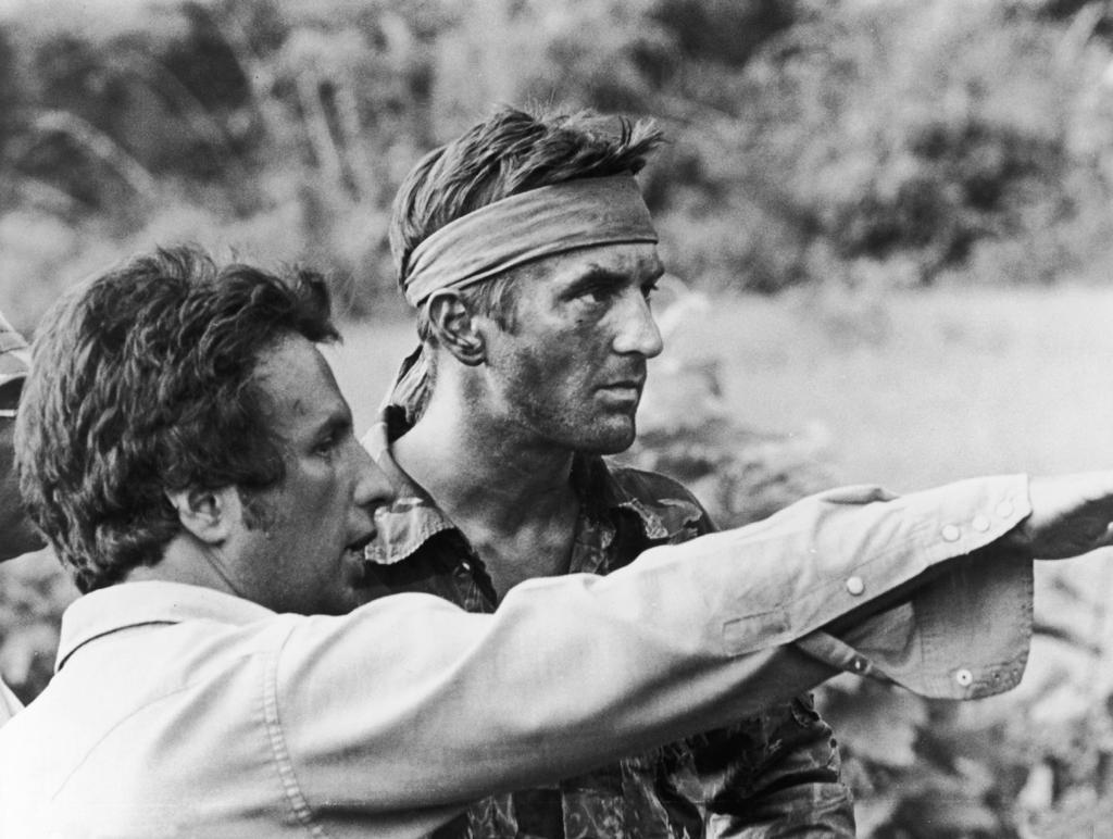 O diretor Michael Cimino (à esquerda) orienta o ator Robert De Niro durante as filmagens de O Franco-Atirador, em 1978 | Divulgação/United Artists