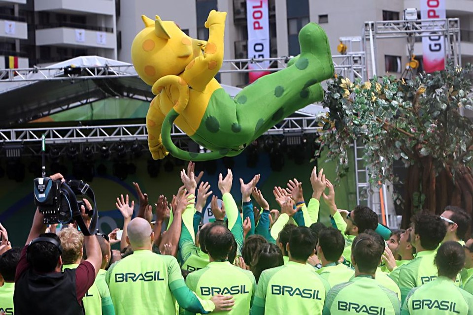 Atletas do Brasil jogam o mascote da delegação, a onça Ginga, para o alto na cerimônia de hasteamento da bandeira na Vila Olímpica. | Albari Rosa/Gazeta do Povo