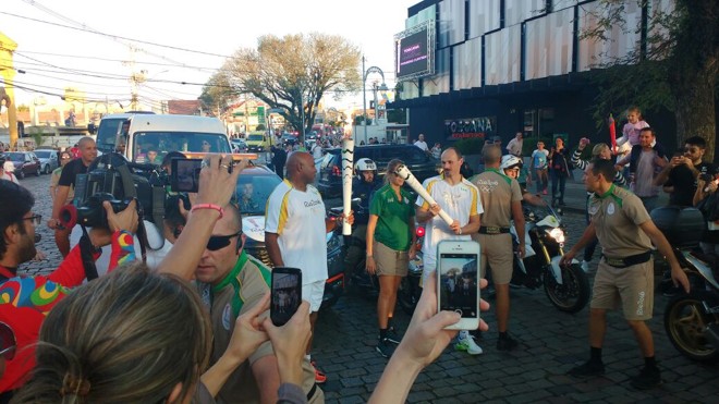 Campeão mundial de rúgbi pela África do Sul, personagem do filme Invictus, Chester Williams recebe a tocha em Santa Felicidade. |