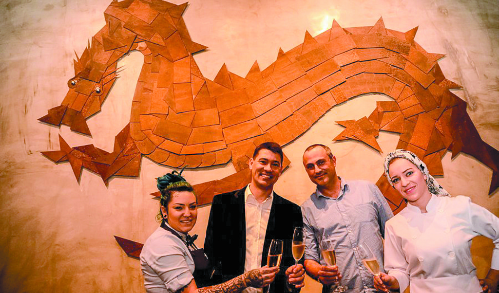 A bartender Emilin Lima e a chef Gi Rotta (à dir.) brindam junto ao painel do dragão, assinado pelo artista Simon Thompson, com os sócios do RYO, Marlon Ançay e Marcelo Marcengo, na inauguração do restaurante asiático, terça-feira, no Batel.