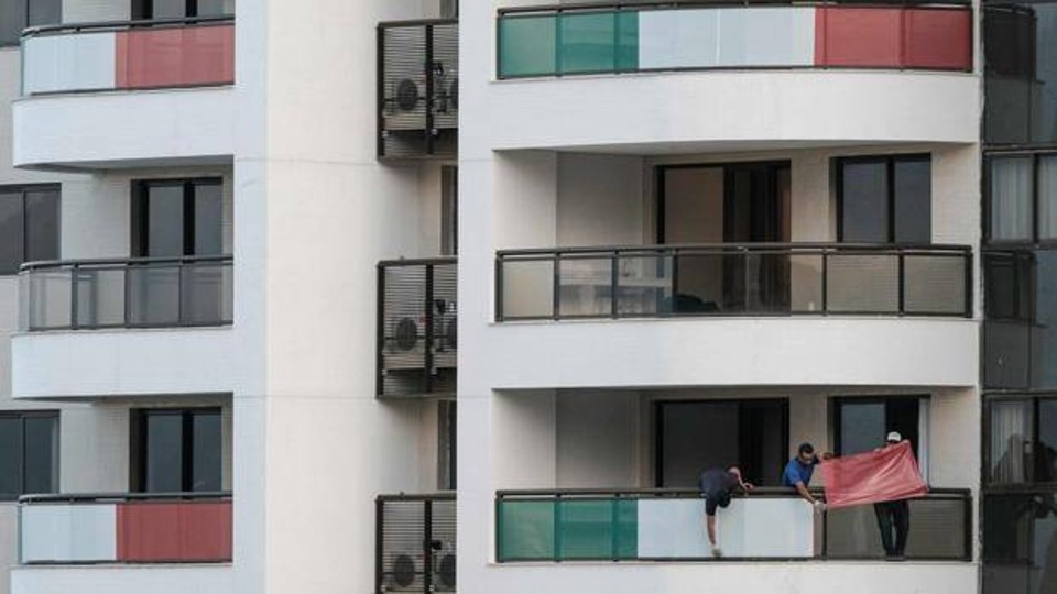 Delegação italiana decora as sacadas dos apartamentos da Vila. | /AFP