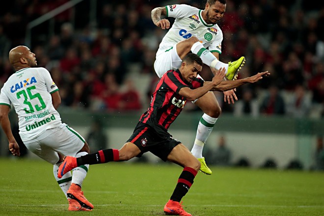 Estreante da temporada, Juninho, do Atlético, quase leva um golpe de vale-tudo em disputa de bola com jogador da Chapecoense: marcação dura. | Albari Rosa/Gazeta do Povo