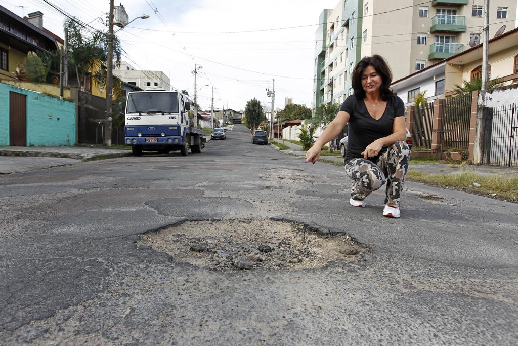 Lenilce Guimarães mostra estado precário da via onde mora. | Antônio More/Gazeta do Povo