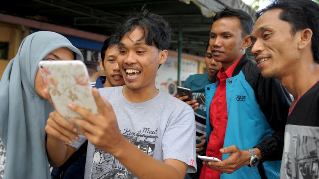Grupo caça pokemons na cidade de Banda Aceh; game ainda não está disponível no país, mas algumas pessoas conseguiram fazer download ilegal. | CHAIDEER MAHYUDDIN/AFP