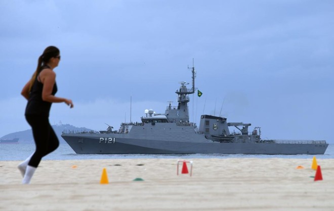 Turista passa por navio da Marinha em Copacabana: prisão de acusados de terrorismo aperta o cerco da segurança no Rio. | VANDERLEI ALMEIDA/AFP