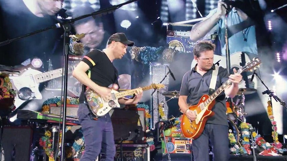 Michael J. Fox “invade” show do Coldplay e toca músicas do filme “De Volta para o Futuro”. Assista Michael J. Fox no palco com o Coldplay | /Reprodução