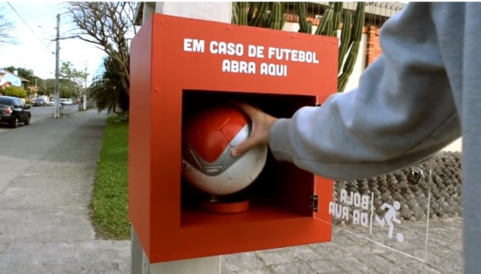Marca de biscoito faz ação inusitada para crianças jogarem bola na rua; veja vídeo Marca ofereceu bolas para que crianças pratiquem o futebol nos bairros. | /