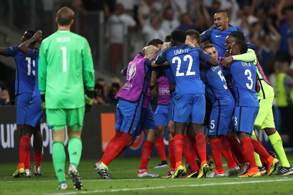 Jogadores da França comemoram a classificação à final da Eurocopa;,ao lado, o goleiro Neuer caminha desolado. | Valery Hache/AFP