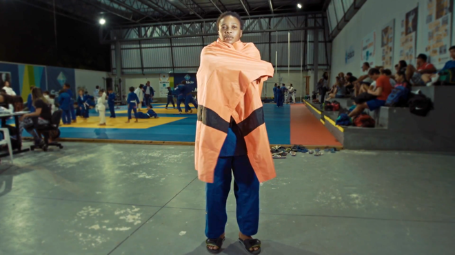 Judoca congolesa Yolanda Bukasa, que mora no Rio desde 2013, com a bandeira da equipe olímpica de refugiados da Rio-2016. | The Refugee Nation/