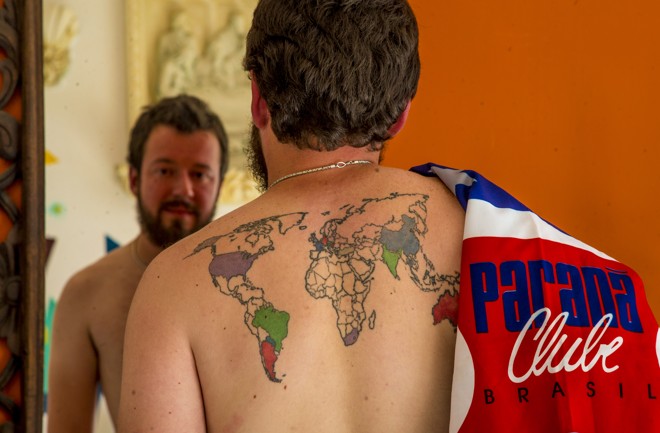 Guilherme com a bandeira do Paraná e o mapa mundial tatuado nas costas. A cada nova viagem, o paranista preenche o mapa. | Hugo Harada/Gazeta do Povo
