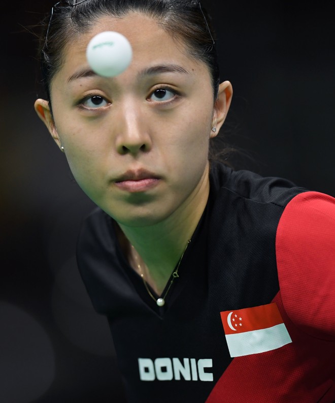 Yu Mengyu, de Cingapura, observa a bola antes de efetuar saque contra norte-coreana Kim Song I - | JIM WATSON/AFP