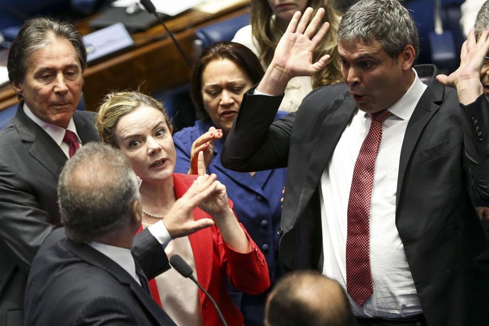 Gleisi (de vermelho) discute com Renan Calheiros (de costas) ao lado de Lindbergh Farias (com as mãos ao alto) | MARCELO CAMARGO/AFP