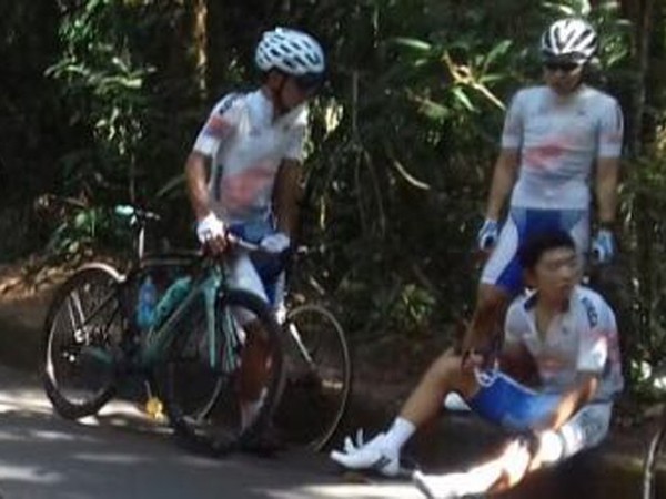 Ciclista coreano sentado, aguardando atendimento médico | /Polícia Rodoviária Federal