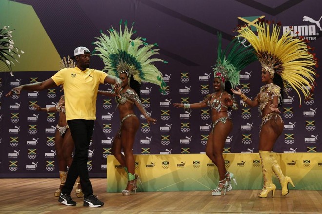 Bolt não se intimidou com a presença de passistas e se arriscou no samba | ADRIAN DENNIS/AFP