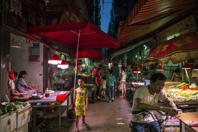 Uma das vielas comerciais do conjunto de vilas de Baishizhou, com migrantes e imigrantes que ajudaram a erguer a cidade de Shenzen. Vários moradores estão à espera de despejo para dar lugar a novos distrito industriais e comerciais | LAM YIK FEI/NYT