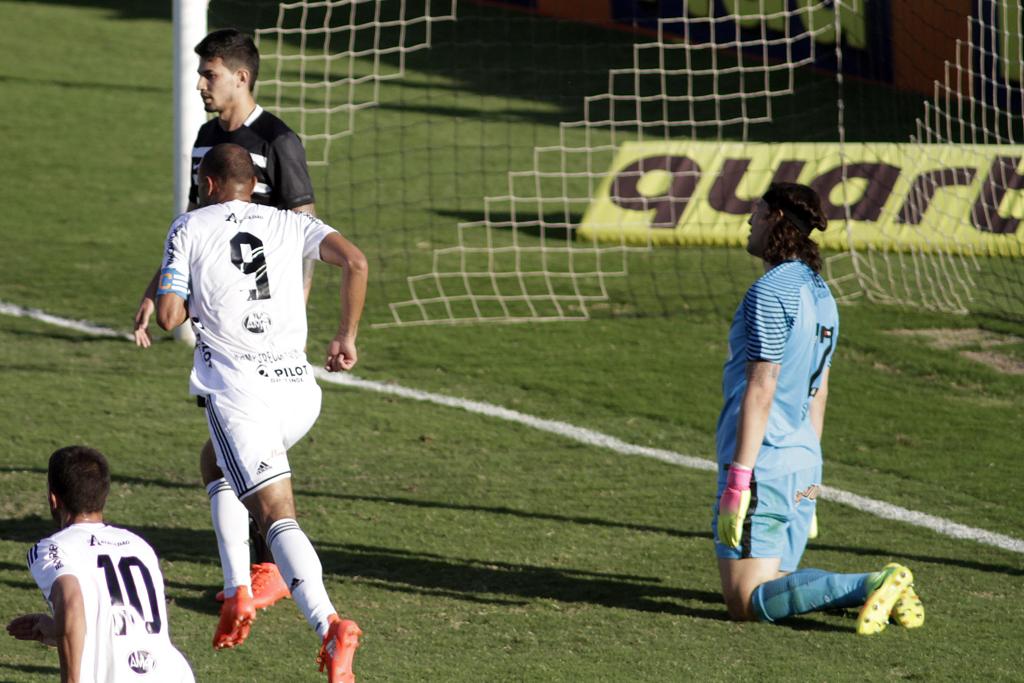 De joelhos, Cássio lamenta o gol da Ponte Preta. Roger, com a camisa 9, festeja o triunfo da Macaca. | Denny Cesare/Codigo19/Folhapress