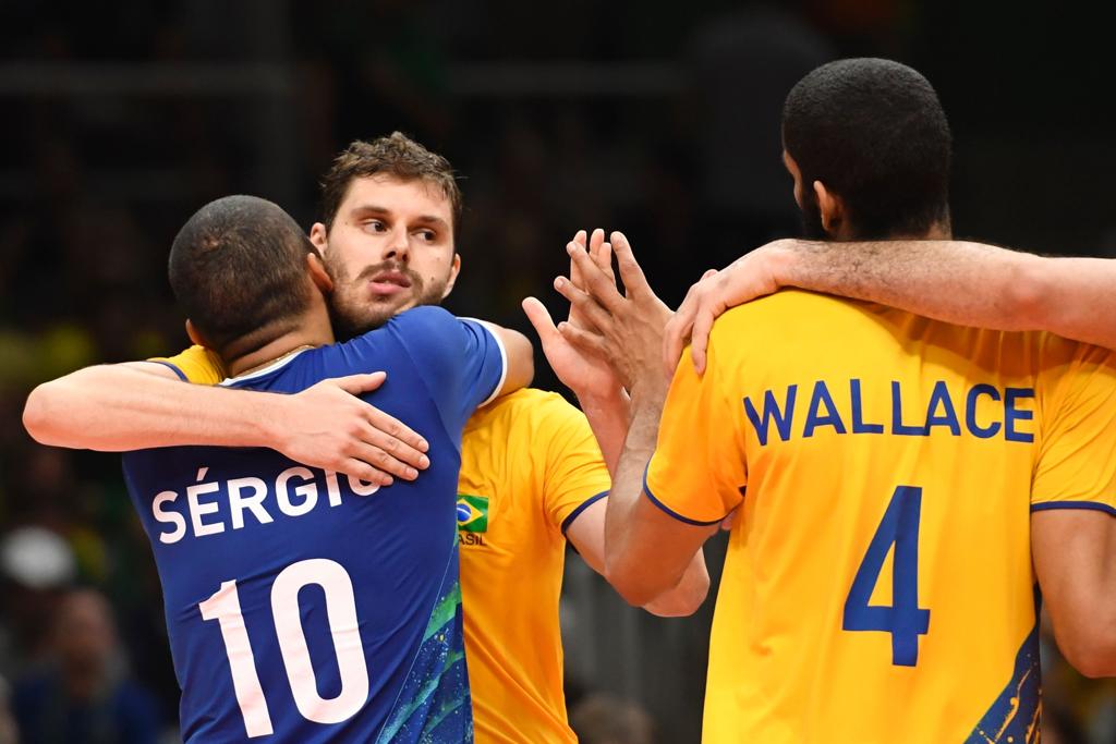 Bruninho abraça Serginho e Wallace após a vitória. Equipe terá que superar problemas físicos contra a Rússia. | ERIC FEFERBERG/AFP