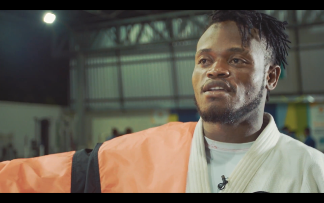 Judoca Popole Misenga, do Congo e que mora no Rio, com a bandeira da equipe olímpica de refugiados. | The Refugee Nation