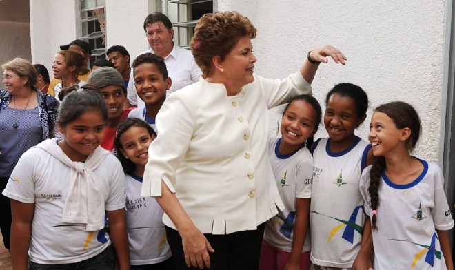 Como candidata à presidência do Brasil, Dilma tira fotos com criança durante visita em orfanato em Brasília, em outubro de 2010. | Evaristo Sá