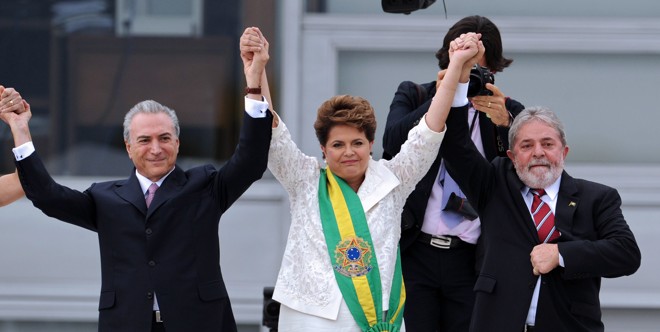 Foto de janeiro de 2011 mostra a ex-presidente Dilma tomando posse de seu primeiro mandato. Acompanhada do atual presidente Michel Temer e do ex-presidente Luís Inácio Lula da Silva, comemora o início de seu governo. | Evaristo Sá/AFP