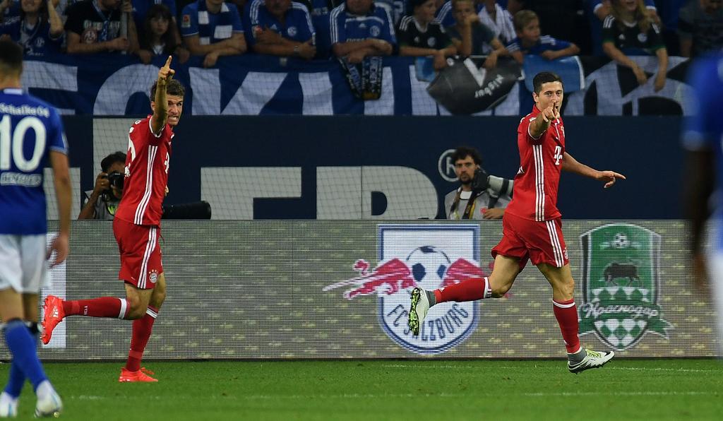 Thomas Müller e Robert Lewandowski comemoram o gol do polonês na vitória do Bayern de Munique sobre o Schalke 04. | Patrik Stollarz/AFP