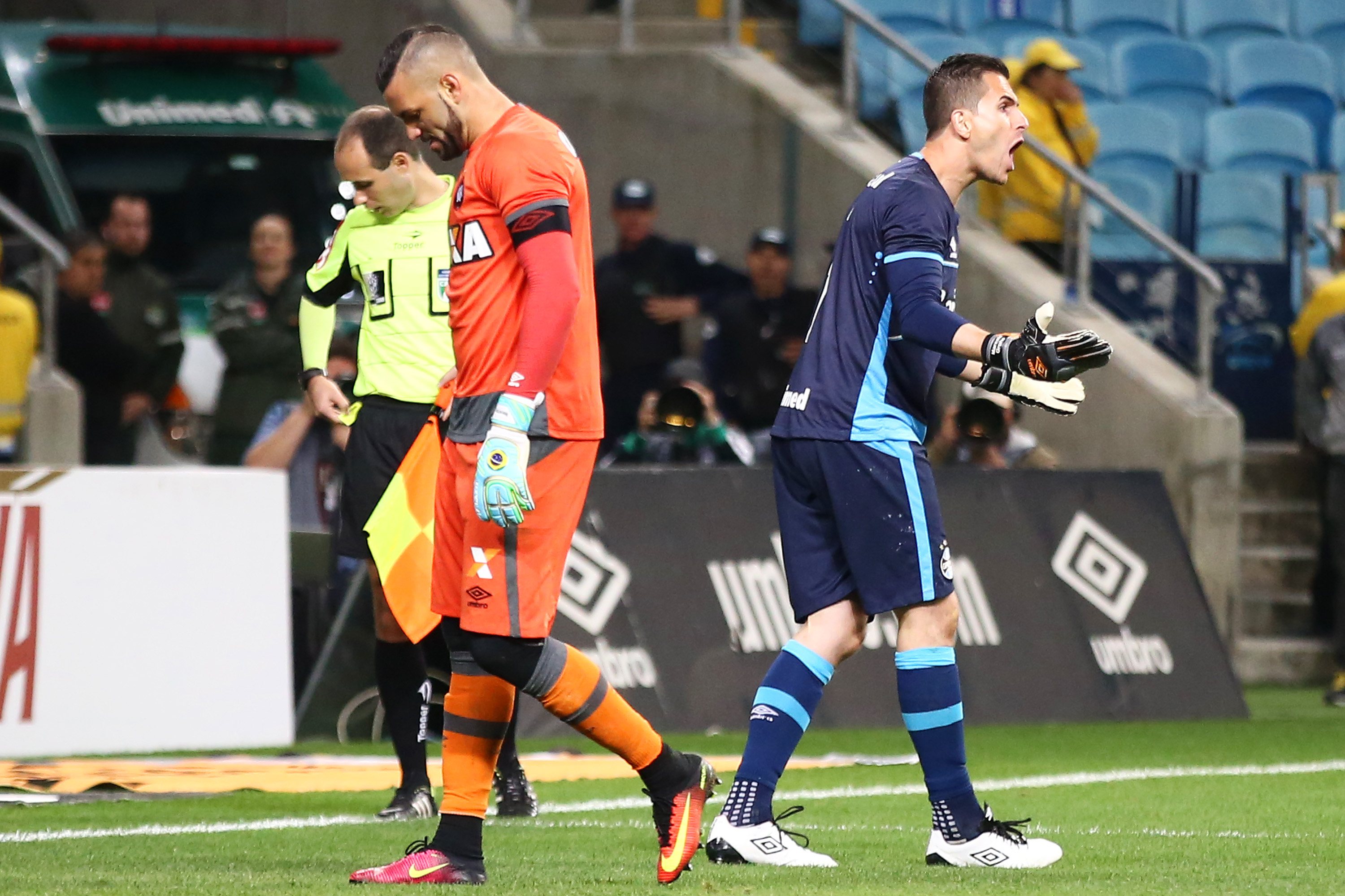 Weverton lamenta após ter desperdiçado a cobrança que daria a vitória para o Furacão, enquanto Marcelo Grohe comemora a defesa. | PEDRO H. TESCH/ESTADÃO CONTEÚDO