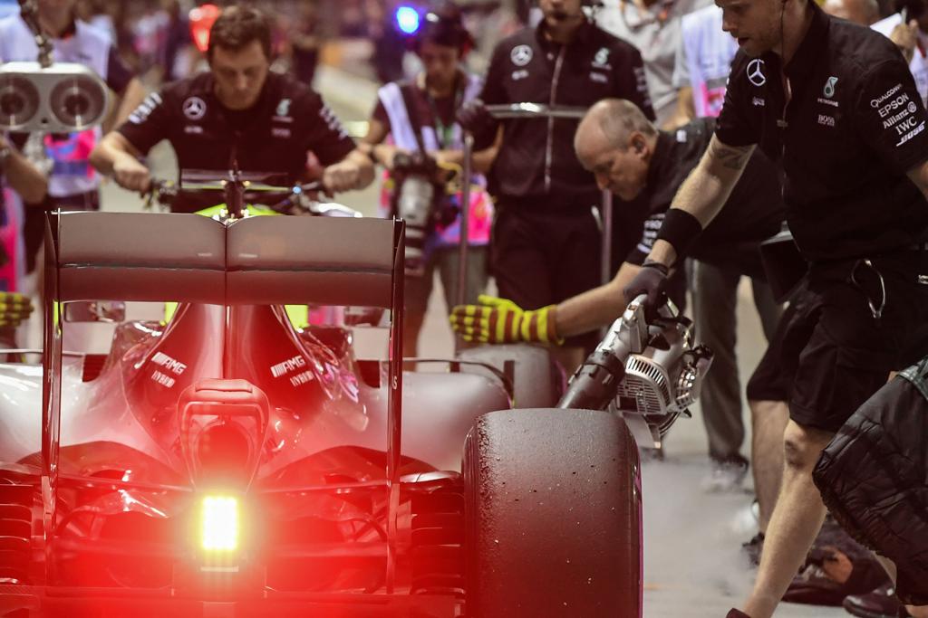 Equipe da Mercedes trabalha na troca de pneus e no reabastecimento do carro de Rosberg durante treino livre em Cingapura. | Mohd Rasfan/AFP