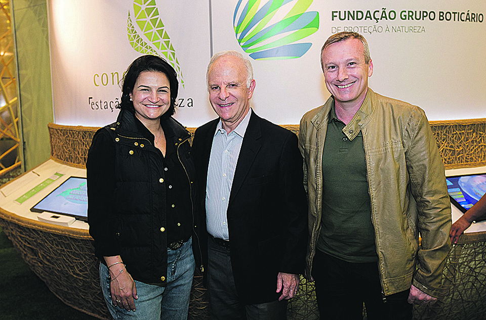 Fundador do Grupo Boticário e idealizador da Fundação Grupo Boticário de Proteção à Natureza, Miguel Krigsner (ao centro) compareceu à exposição itinerária Conexão Estação Natureza, no Shopping Mueller, onde foi recebido pela superintendente do shopping, Daniela Baruch, e pelo diretor, Nelsi Frizzo. | Divulgação