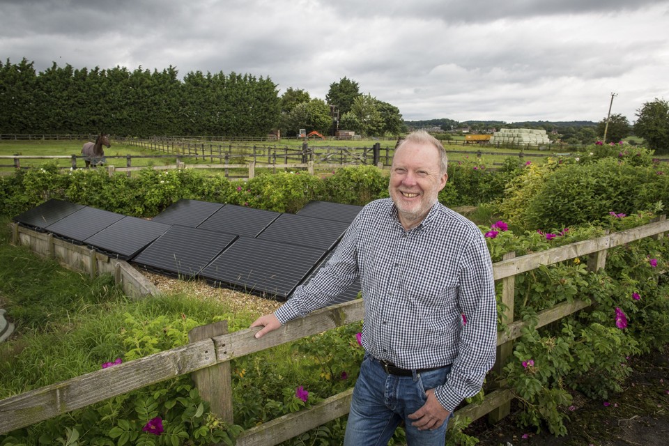Garry Charnock , o ex- jornalista que iniciou um projeto de carbono neutro em Ashton Hayes , Inglaterra, ao lado de painéis solares na aldeia. Em Ashton Hayes , os moradores uniram-se com sucesso em conjunto para reduzir as emissões de efeito estufa em quase um quarto com energia solar , noites de vinho e queijo e longe dos políticos . | ELIZABETH DALZIEL/NYT