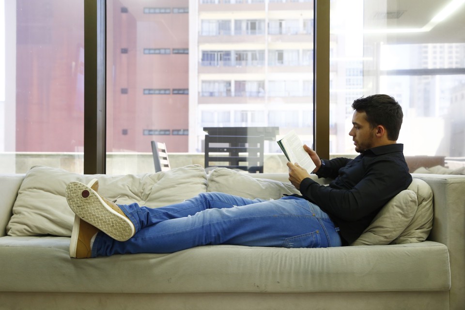 Leandro  Mendes, funcionário da MadeiraMadeira,  lê um livro para aliviar a tensão do dia a dia. A empresa mantém um espaço  tranquilo para descontração. | Henry Milleo/Gazeta do Povo