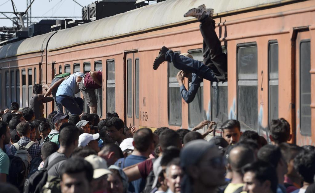 Em foto de 2015, migrantes se espremem em trem para cruzar a fronteira da Macedônia com a Grécia | Georgi Licovsi/EFE