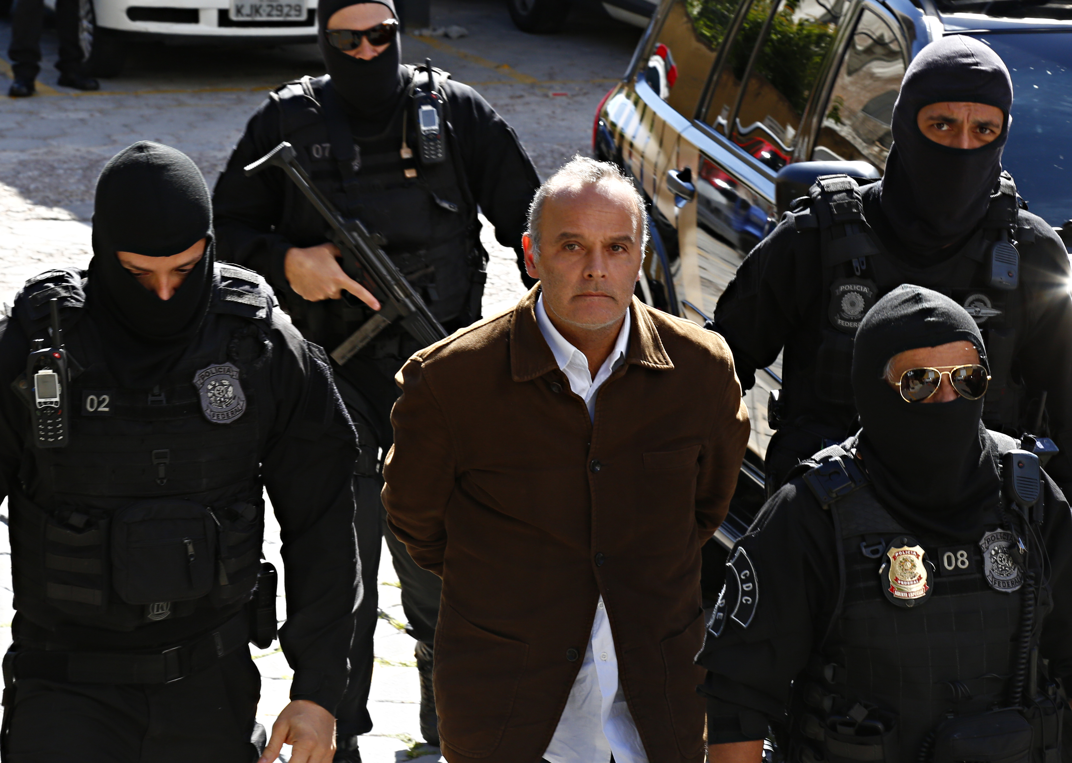 Wilson Carlos é escoltado por policiais encapuzados para fazer o exame de corpo de delito no IML. | Aniele Nascimento/Gazeta do Povo