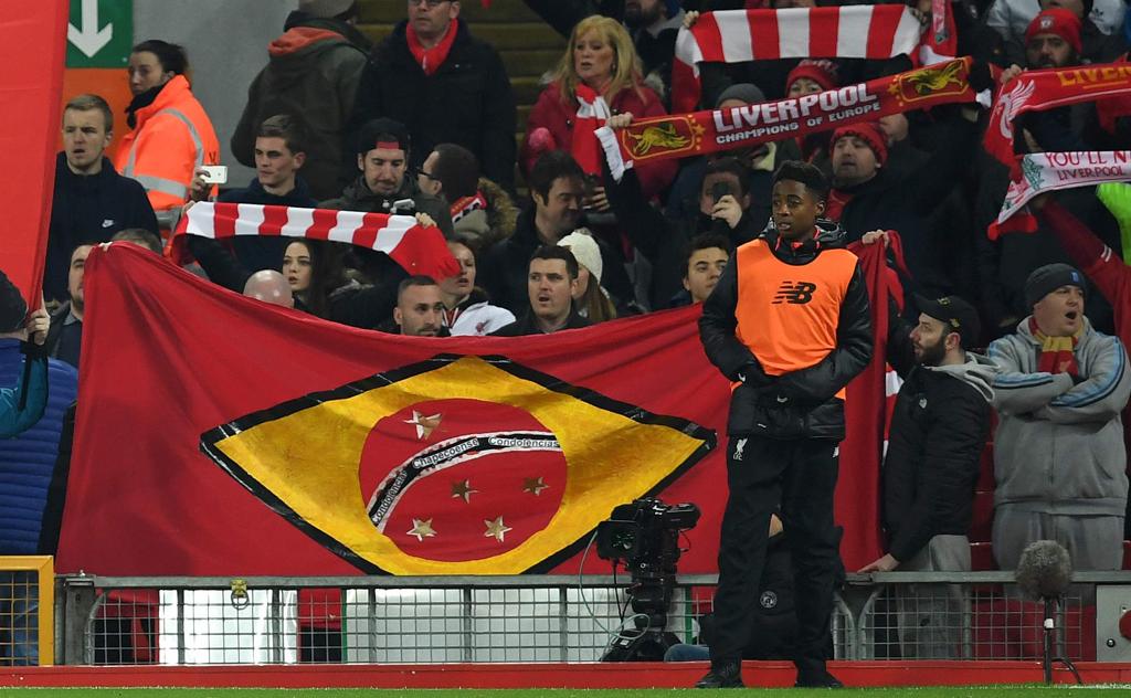 Torcedor do Liverpool com a bandeira brasileira nas cores do clube inglês e a frase “Concolência Chapecoense” | PAUL ELLIS/AFP