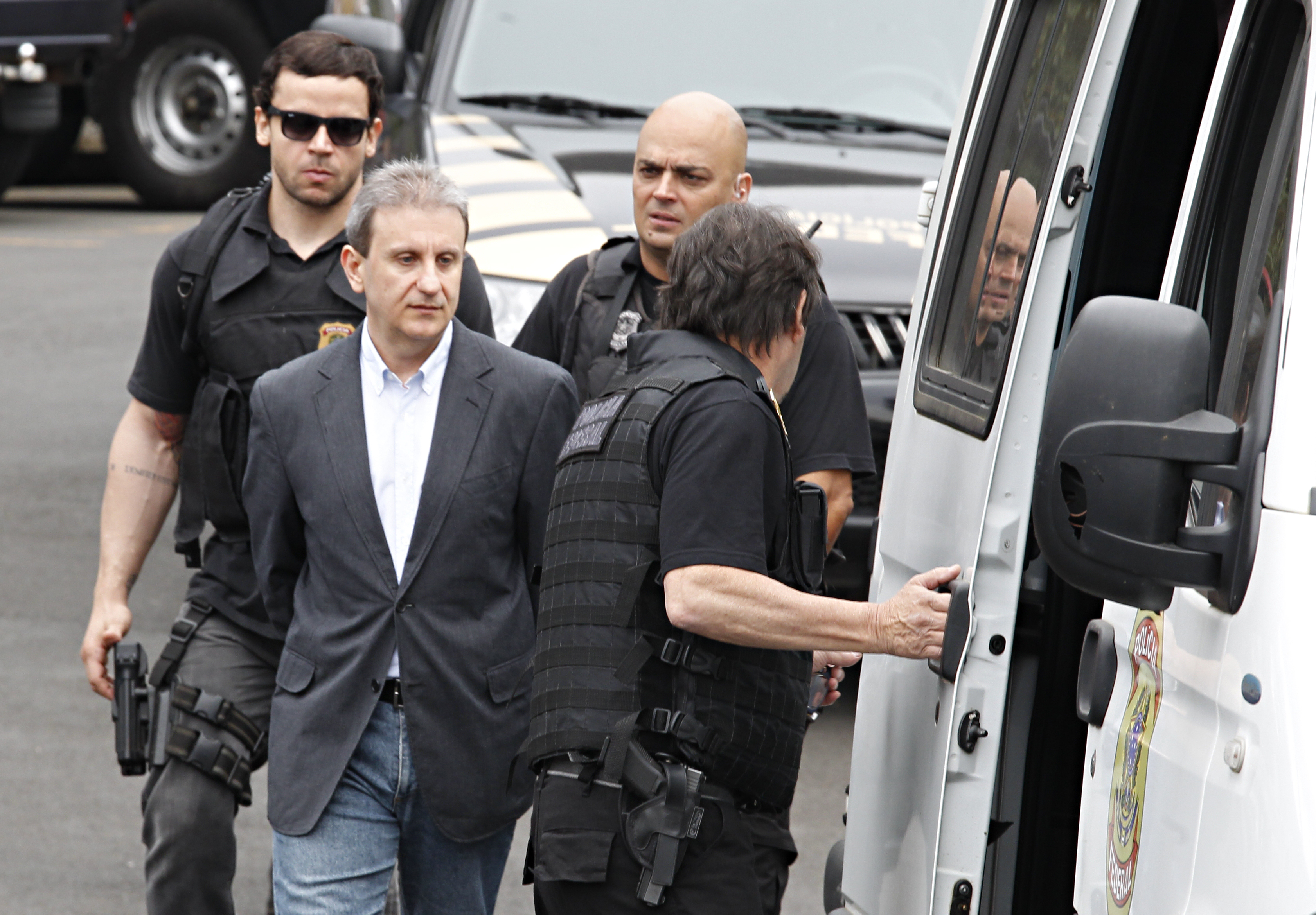 Youssef (de camisa branca) conduzido por policiais federais para um depoimento: ajuda nas investigações rendeu pena bem menor ao doleiro. | Aniele Nascimento/Gazeta do Povo