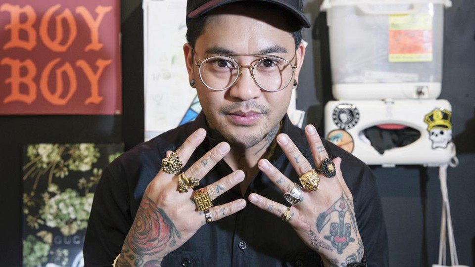 Valena se descreve como “um filipino pequeno e baixinho”: tem os braços e pernas cheios de tatuagens. As mãos, além de cheias de símbolos e desenhos, também têm o peso de vários anéis de ouro grandes de Gucci e Versace | Ben Sklar/NYT