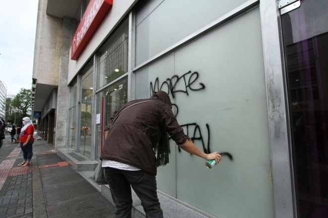 Vandalismo: Manifestantes picham portas de lojas na Rua Marechal Floriano. Ao menos três bancos tiveram suas portas estilhaçadas por pedras lançadas por pessoas que acompanham o ato. | Rodrigo Félix/Gazet a do Povo