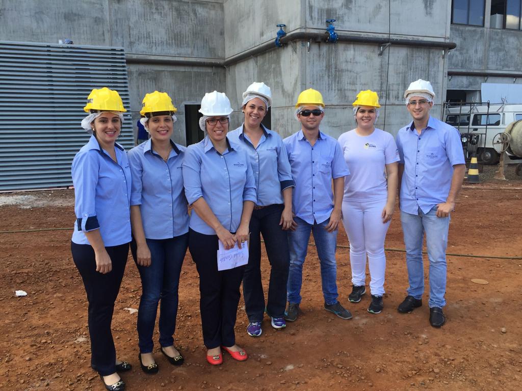 Colaboradores em frente a nova sede que está em construção | Divulgação