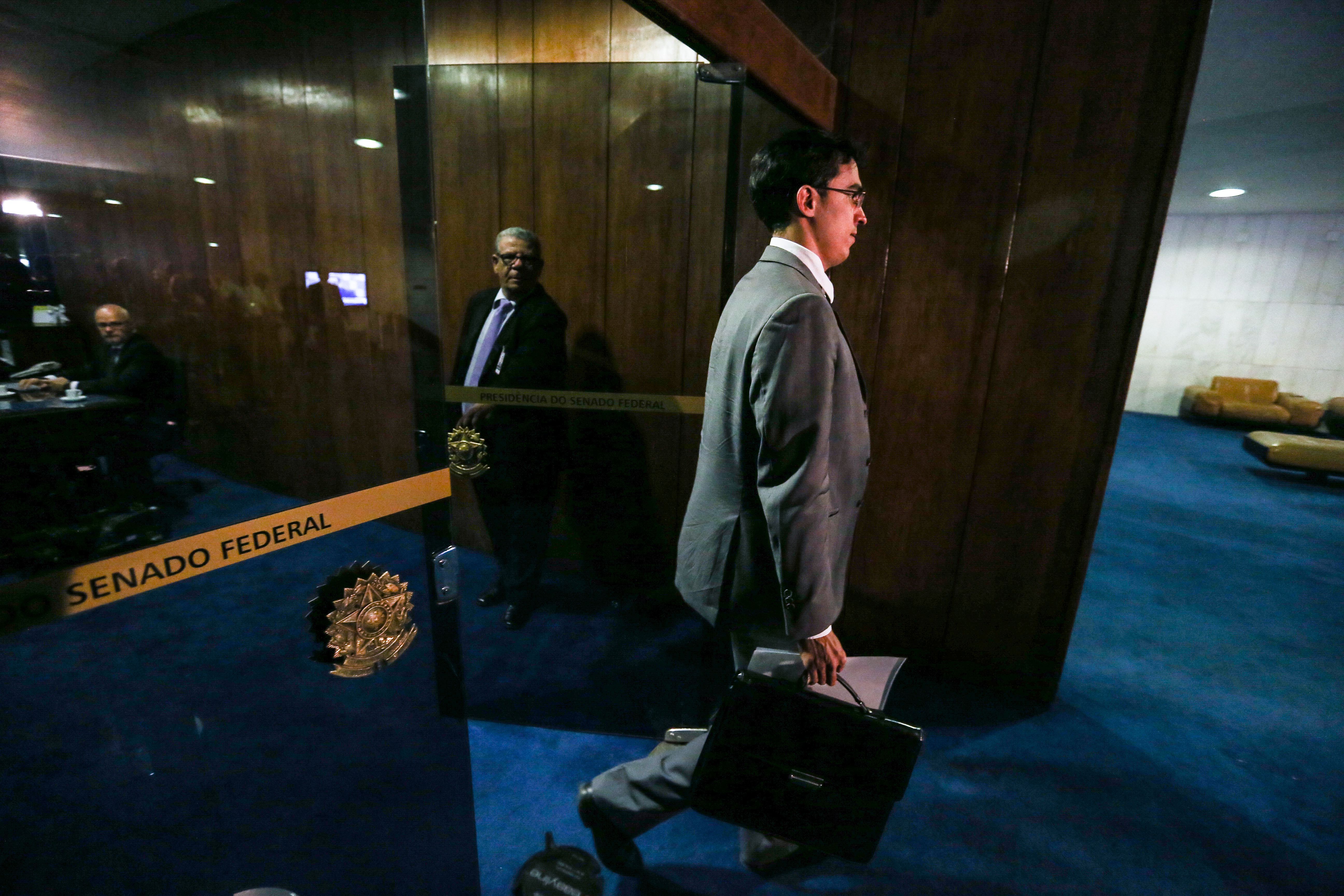 O oficial de Justiça deixa a casa após tentar entregar a notificação de afastamento a Renan Calheiros | Fabio Rodrigues Pozzebom/Agência Brasil