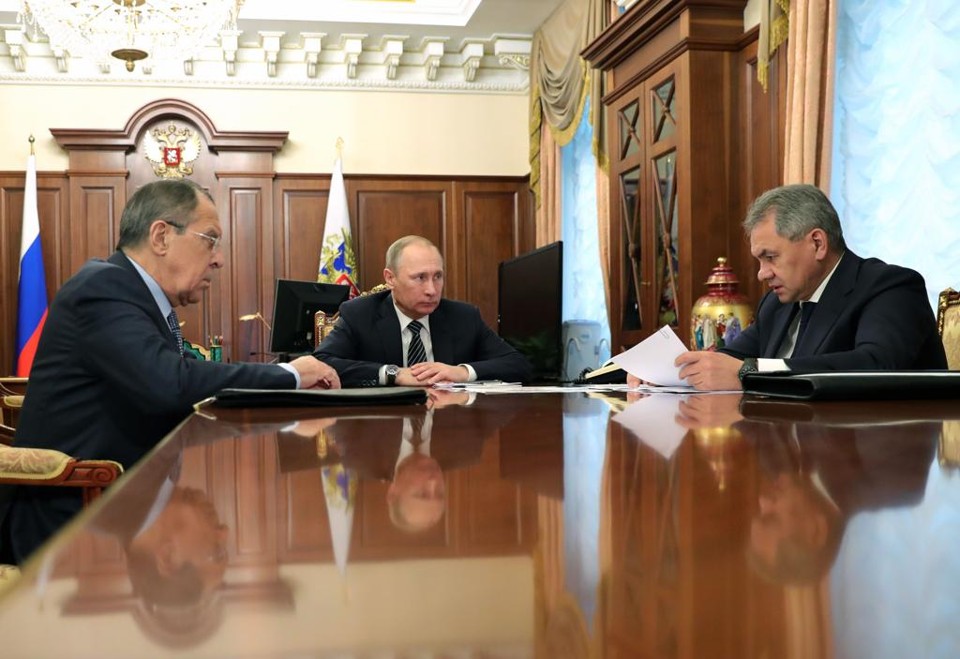 Vladimir Putin (centro) e seus ministros Sergueï Lavrov e Sergueï Choïgou durante a assinatura do acordo de paz | MICHAEL KLIMENTYEV/AFP