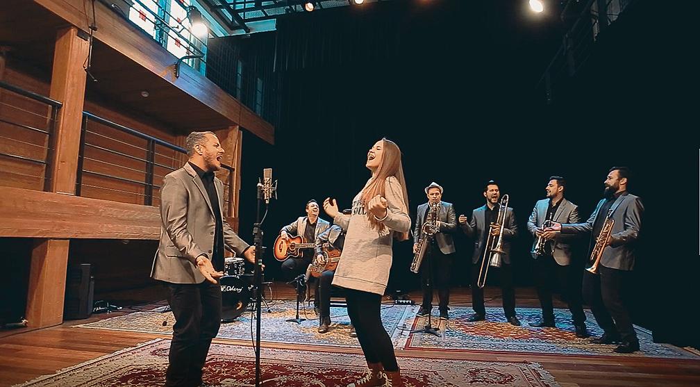 Os intérpretes são Franco Calgaro (Big Time Orchestra) e a cantora Carol Passos na gravação do primeiro episódio | Divulgação/FCC