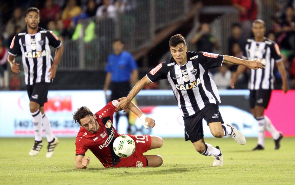 Calhanoglu, do Leverkusen, cai em lance com Thalis, do Atlético-MG. | Gregg Newton/AFP