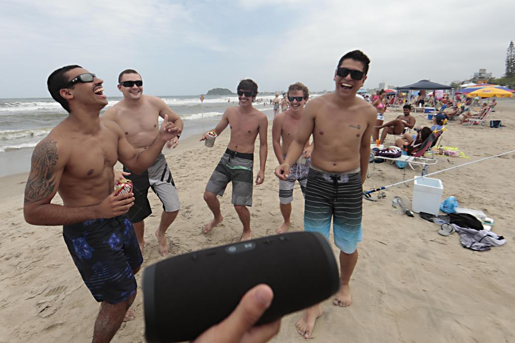 Marcelo Rocha de Bastos e seus amigos em Guaratuba. O educador físico diz que as caixinhas ajudam a animar a praia | Fotos: Albari Rosa/Gazeta do Povo