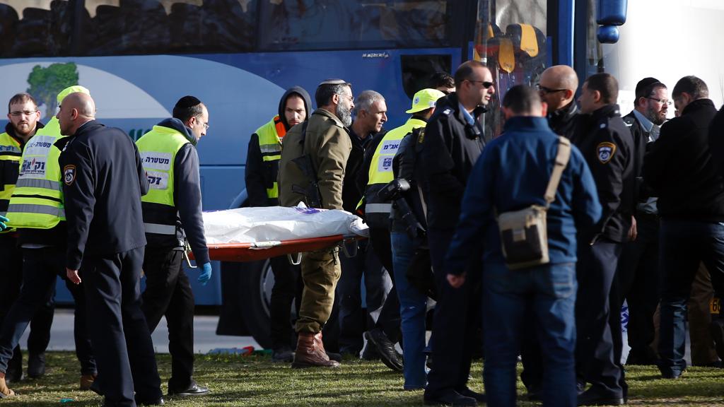 Médicos israelenses levam o corpo de uma vítimas do ataque em Jerusalém. | Ahmad Gharabli/AFP