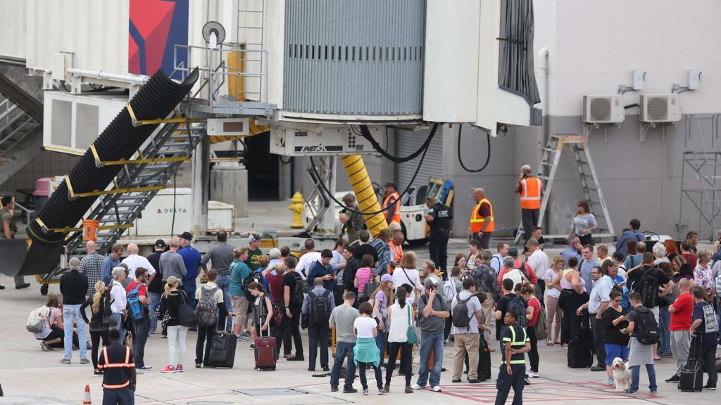 Passageiros se aglomeram no pátio do aeroporto após o ataque do atirador | JOE RAEDLE / AFP